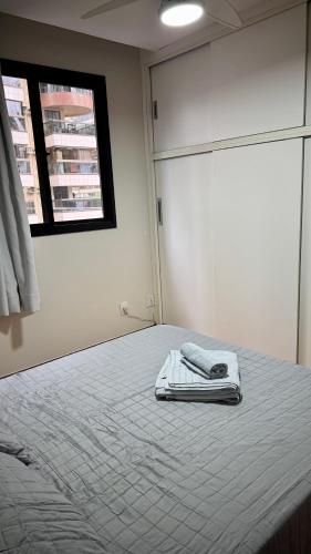 una camera da letto con un letto con due asciugamani sopra di Apartamento moderno a 2 quadras da Praia da Costa - completo, espaçoso e com mimo especial a Vila Velha