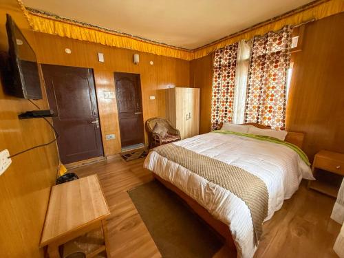 a bedroom with a large bed and a window at JD House in Tawang