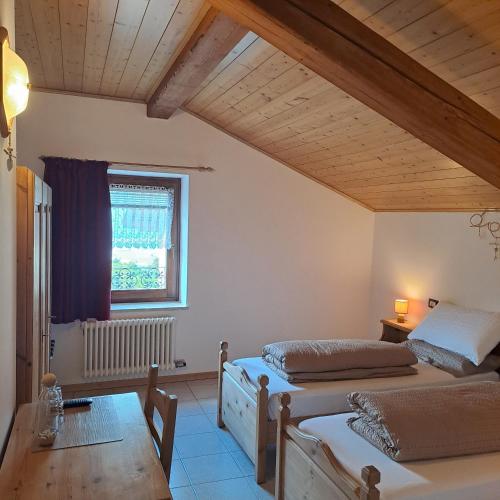 a bedroom with two beds and a window at B&B Casa Zeni in Faedo