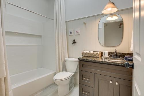 a bathroom with a toilet and a sink and a mirror at Less Than 1 Mi to Butler Beach! Home with Backyard Oasis in Butler Beach