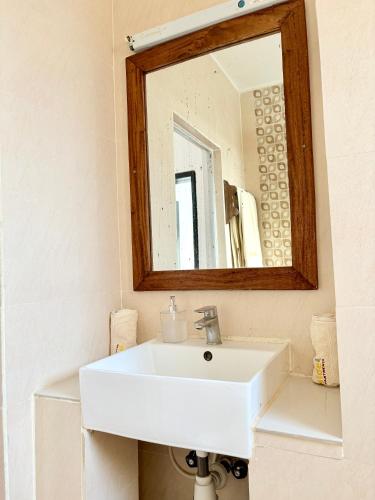 a bathroom with a white sink and a mirror at Wayside Beach Apartments in Diani Beach