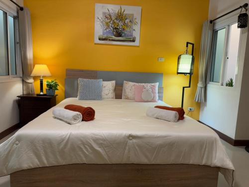 a bedroom with a large bed with two pillows on it at Ao-Nang Private Red House 10 in Ao Nang Beach