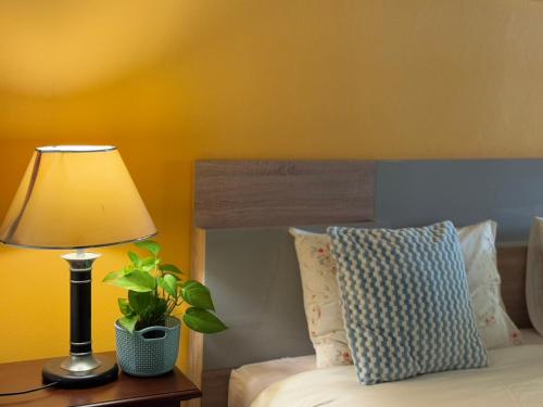 a lamp sitting on a table next to a bed at Ao-Nang Private Red House 10 in Ao Nang Beach