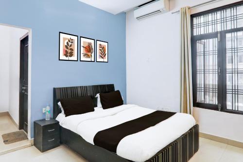een slaapkamer met een groot bed met een blauwe muur bij Hotel O IIDM ECO CENTRE in Lucknow
