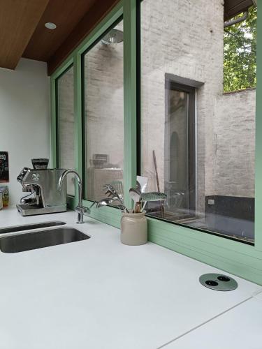 a kitchen counter with a sink and a window at De Steeg in Kalmthout