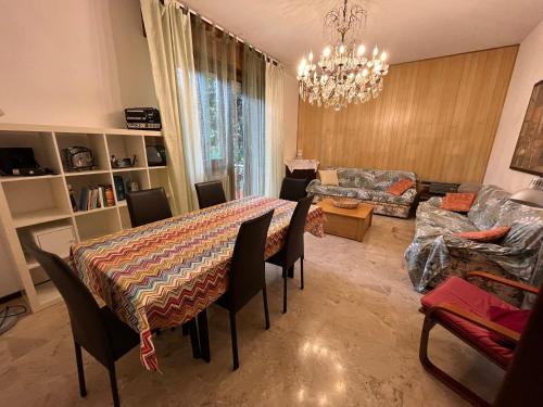 a living room with a table and chairs and a chandelier at Paolo&SilviaHost in Seriate