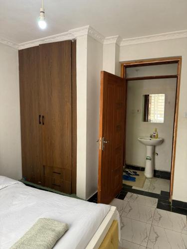 a bedroom with a bed and a bathroom with a sink at 1 Bed in Thika cbd in Thika