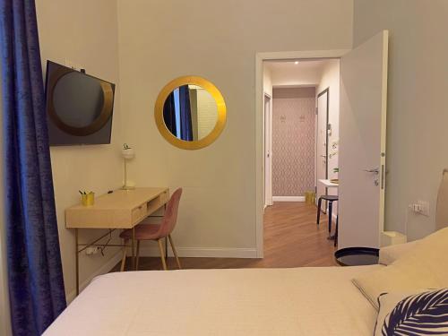 een slaapkamer met een bed, een bureau en een spiegel bij Appartme Stampa 2 in Milaan