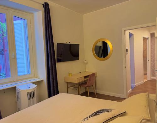een slaapkamer met een bed, een bureau en een televisie bij Appartme Stampa 2 in Milaan