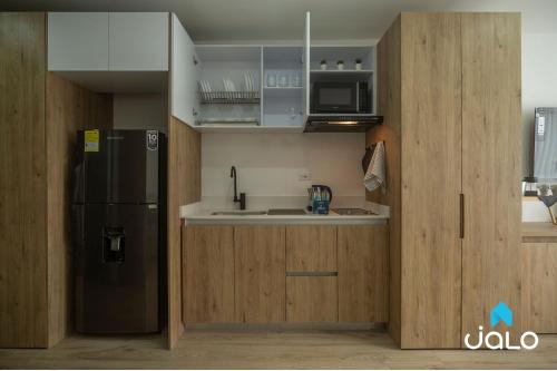 a kitchen with a black refrigerator and a sink at High Park 94 by Jalo in Bogotá