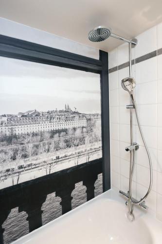 a bathroom with a window with a view of a bridge at Campanile PRIME - Paris Pantin in Pantin