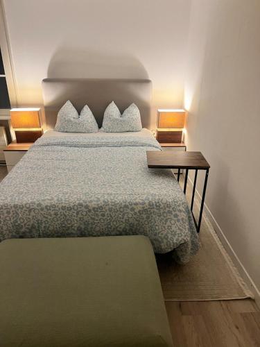 a bedroom with a bed and a nightstand with two lamps at Newly Renovated Stylish & Spacious Studio in Huttwil