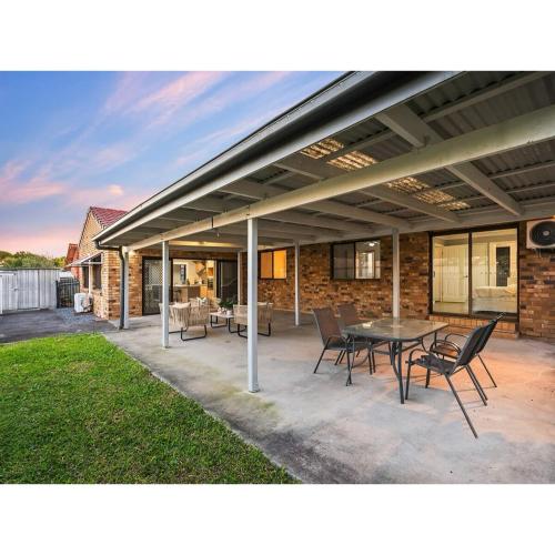 a patio with a table and chairs in front of a house at Spacious Family Retreat in Perfect Location! in Brisbane