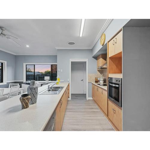 a kitchen with wooden cabinets and a white counter top at Spacious Family Retreat in Perfect Location! in Brisbane