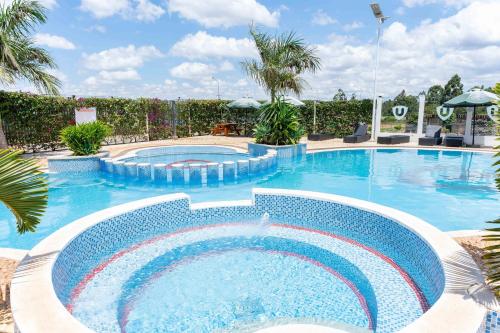 a swimming pool in a resort with palm trees at BethelHomes in Tatu City