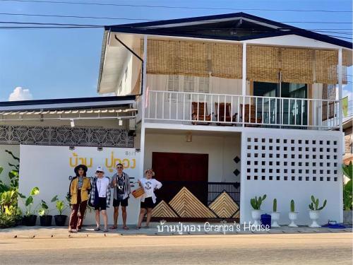 a group of people standing in front of a house at บ้านปู่ทอง Grandpa's House in Chiang Khan