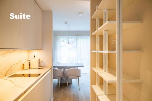 a kitchen with white cabinets and a table at Lindgold in Munich
