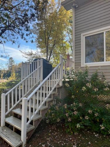 a house with a white staircase next to a house at Le Chalet d'Isabelle in La Conception
