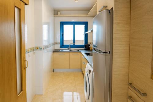 a kitchen with a stainless steel refrigerator and a window at Apartment las sirenas -WiFi 100 Mb-, Sea view in Roquetas de Mar