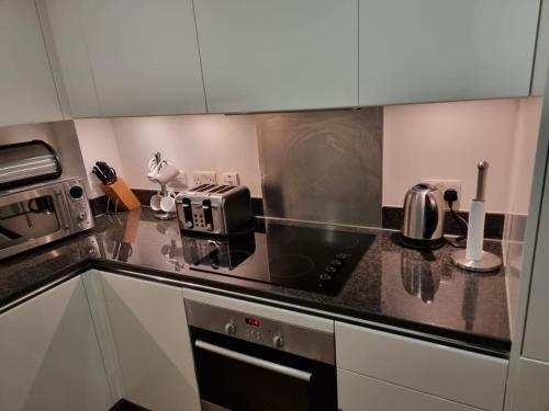 a kitchen with a sink and a stove top oven at luxurious Room with City Views in Woolwich