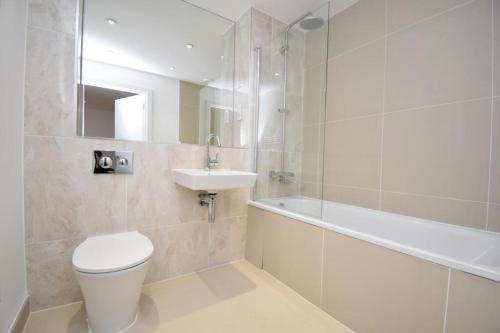a bathroom with a toilet and a sink and a bath tub at luxurious Room with City Views in Woolwich