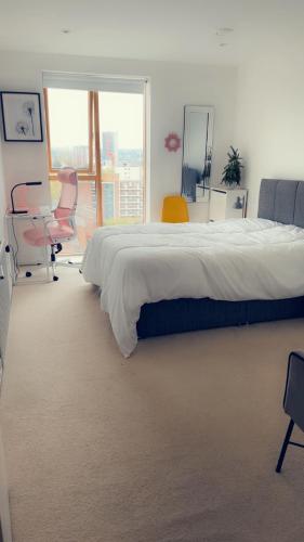 a bedroom with a large bed and chairs and a window at luxurious Room with City Views in Woolwich