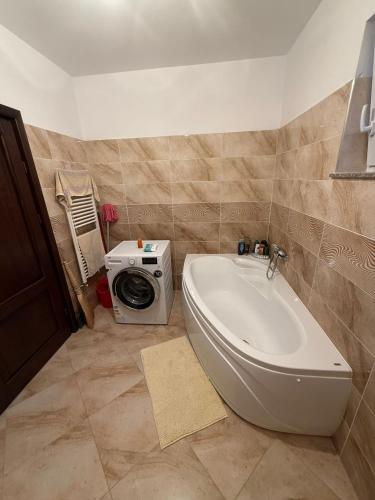 a bathroom with a tub and a washing machine at Apartament cu 2 camere in Rădăuţi