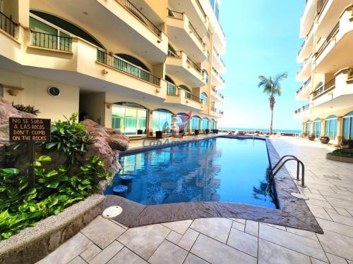 a swimming pool in front of a building at Tiara Sands 302 in Mazatlán