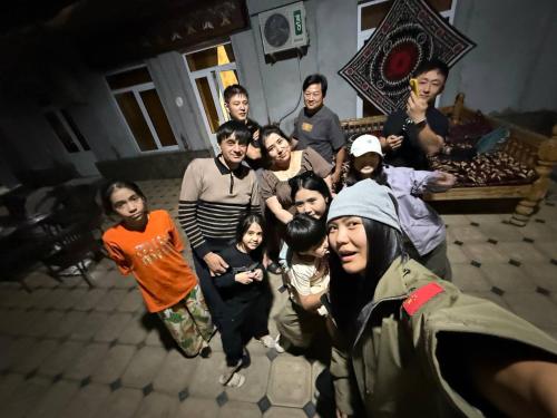 a group of people posing for a picture in a room at Nuriya Guest House in Samarkand