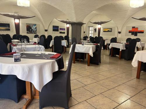 a dining room with tables and chairs with white tables at Les Hirondelles in Orcines