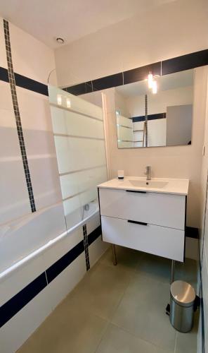 a bathroom with a sink and a bath tub at Villa Garance Ile et Villas Groix in Groix