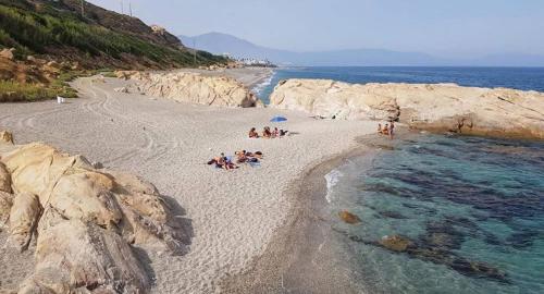 a group of people laying on a beach near the water at Acogedora Casa con terraza en Manilva in Manilva