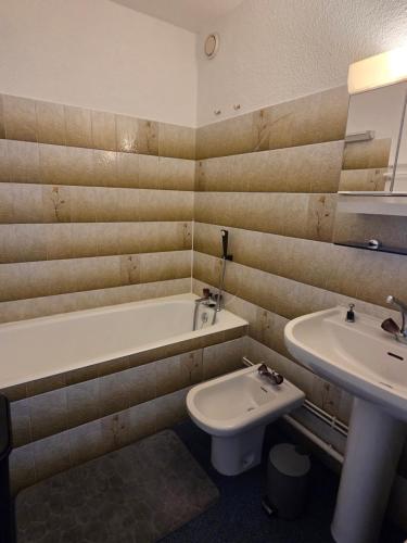 Un baño con lavabo, bañera e inodoro. en Studio 11 pour 4 personnes, en Saint-Honoré