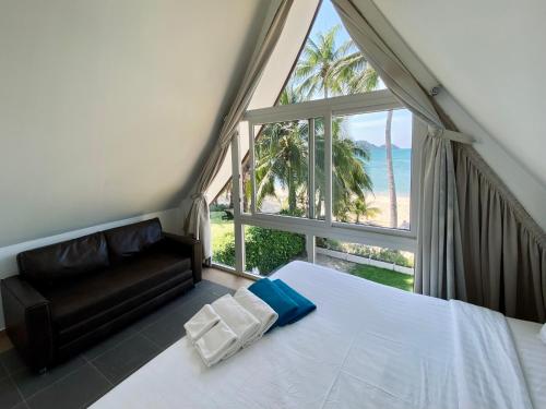 a bedroom with a bed and a view of the ocean at Urai Villa by Utalay Koh Chang in Ban Khlong Son
