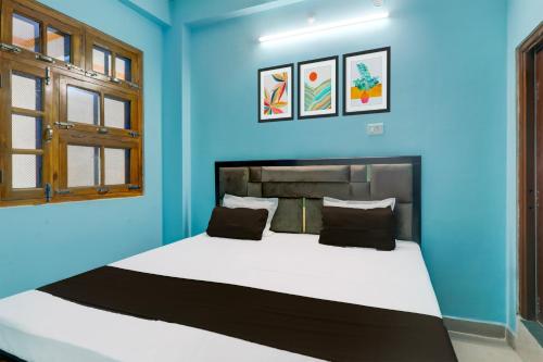 a blue bedroom with a large bed in it at Hotel O SK in Sītāpur