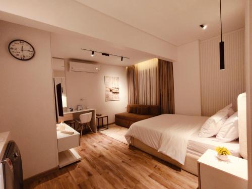 a bedroom with a bed and a desk and a clock at غرفة فندقية مريحة في قلب التجمع الخامس in Cairo