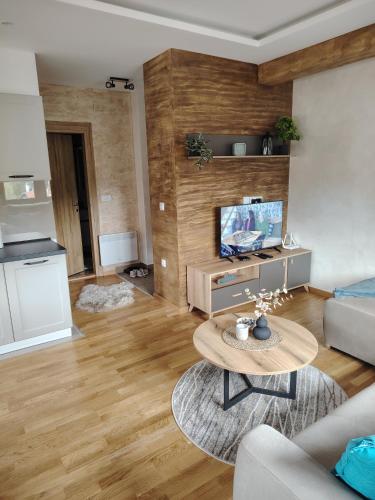 una sala de estar con un sofá y una mesa en Apartman Havjar Zlatibor, en Zlatibor