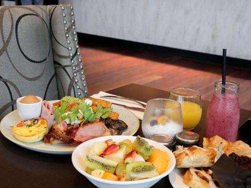 a table with two plates of food and some drinks at Pullman Brisbane Airport in Brisbane