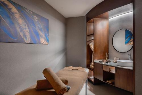 un bagno con un letto, un lavandino e uno specchio di Radisson Blu Hotel, Amman Galleria Mall ad Amman