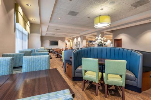 a dining room with blue chairs and a table at Drury Plaza Hotel Columbia East in Columbia