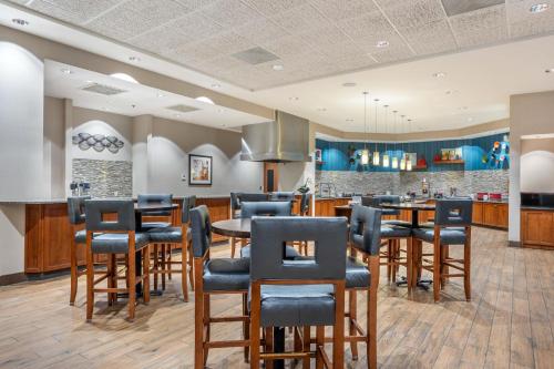 a restaurant with a bar with blue chairs at Drury Plaza Hotel Columbia East in Columbia