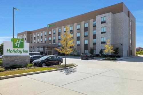 a large building with cars parked in a parking lot at Holiday Inn - Chicago - Tinley Park by IHG in Tinley Park