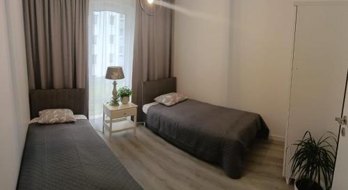 a small bedroom with a bed and a window at Apartament MajaHouse 2 in Nowa Sól