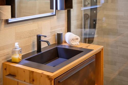 La salle de bains est pourvue d'un lavabo et d'une serviette sur un comptoir. dans l'établissement Sonne Oase mit Sauna, à Fiesch