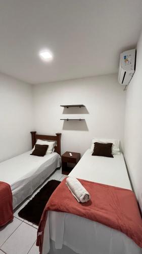 two beds sitting next to each other in a room at Apartamento Vila Isabel in Maragogi