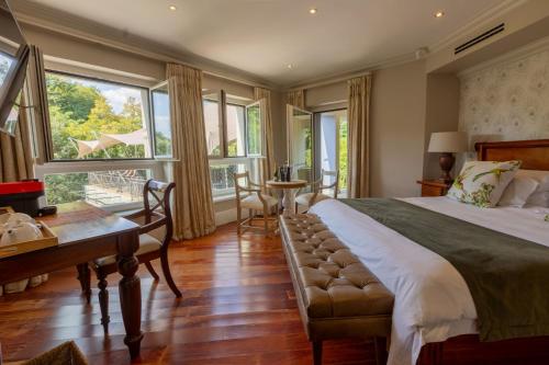 une chambre avec un lit, un bureau et des fenêtres dans l'établissement The 506 Hotel, à Midrand
