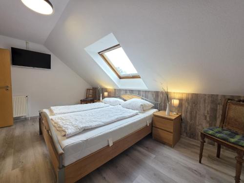 Komfortferienhaus Küstenruhe Norddeich في Flüthörn: غرفة نوم مع سرير وفتحة سقف