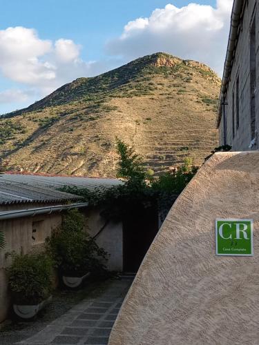 a building with a mountain in the background at Vivienda de Turismo Rural Granja La Lomica in Ladruñán