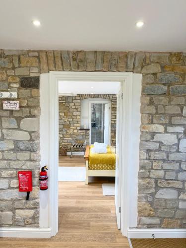 a room with a stone wall and a bedroom at Guest Suite King Bed in Chew Valley Bath Somerset in Chew Magna
