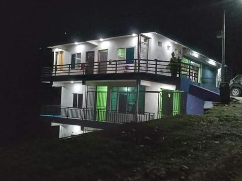 a house with a reflection in the water at night at Hotel bright moon lake in Deorāli